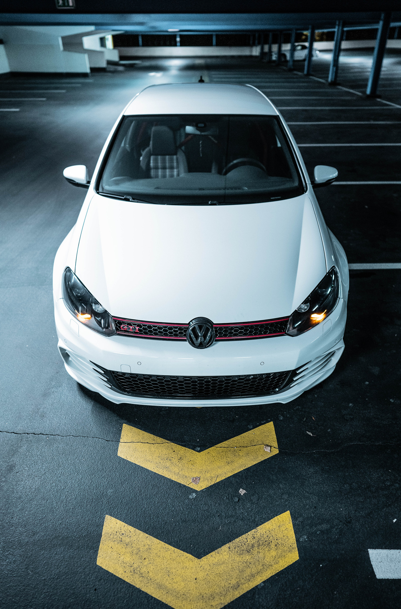 This image shows the arial view of a car parked in a parking garage.